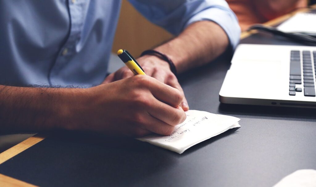 Copywriter profissional escrevendo em mesa de trabalho — SEO copywriting e estratégia de conteúdo